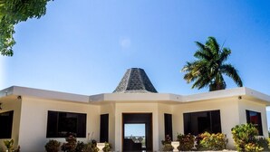 Um edifício moderno com entrada central, janelas amplas e telhado inclinado.