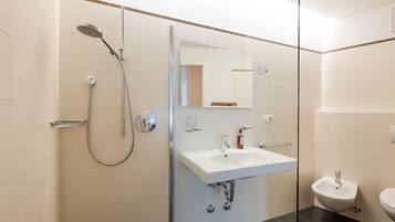 Un baño moderno con ducha, lavamanos y bidé.