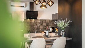 A modern kitchen with a dining area, featuring a patterned backsplash, a flat-screen TV, and a vase with flowers. - Luxurious home in Betina (Betina)