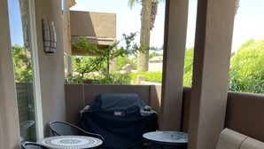 A patio area with a covered grill, two round tables, and four chairs. - Beautiful ground floor condo in St. George, Utah (St. George)