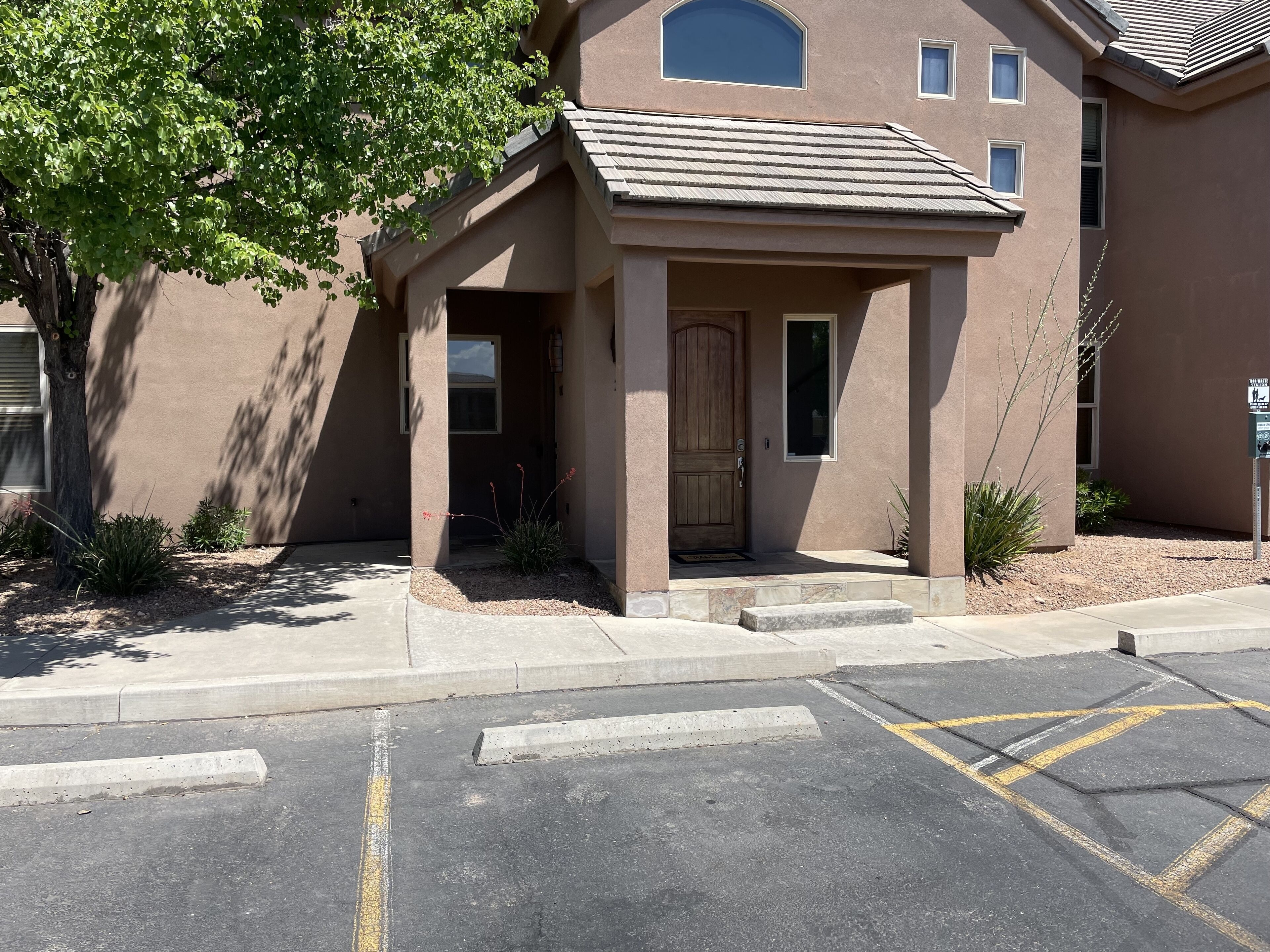 A building with a covered entrance, a door, and a small porch area.