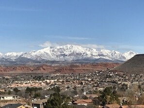 Une ville dominée par des montagnes enneigées en arrière-plan, avec un mélange de bâtiments résidentiels au premier plan.