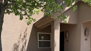 A building entrance with a concrete pathway, a small window, and a door marked with the number 102. - Beautiful ground floor condo in St. George, Utah (St. George)