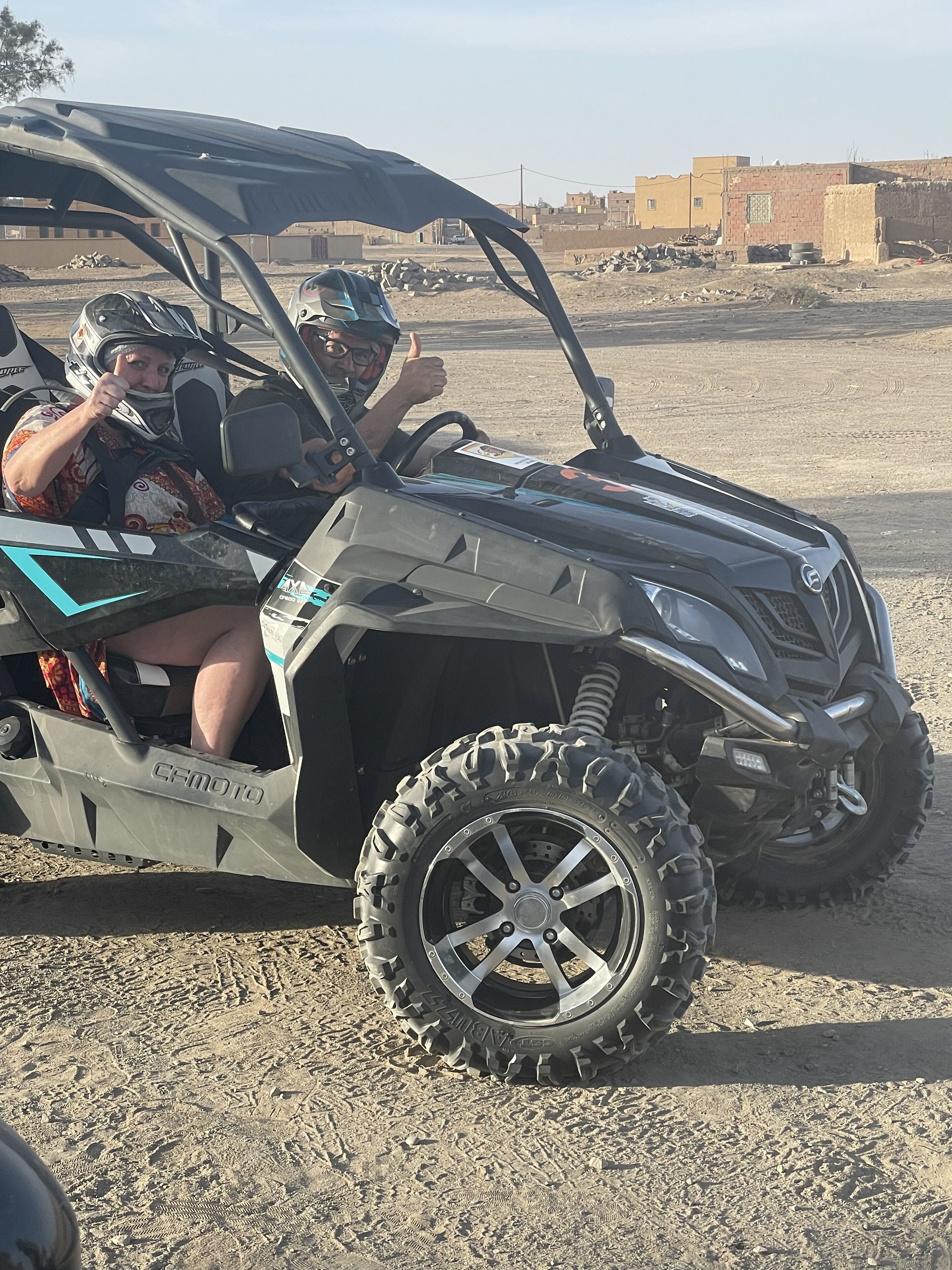 A vehicle with large off-road tires and a protective canopy.