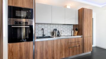 Een moderne keuken met houten kastjes, roestvrijstalen apparatuur en een backsplash van hexagontegels.