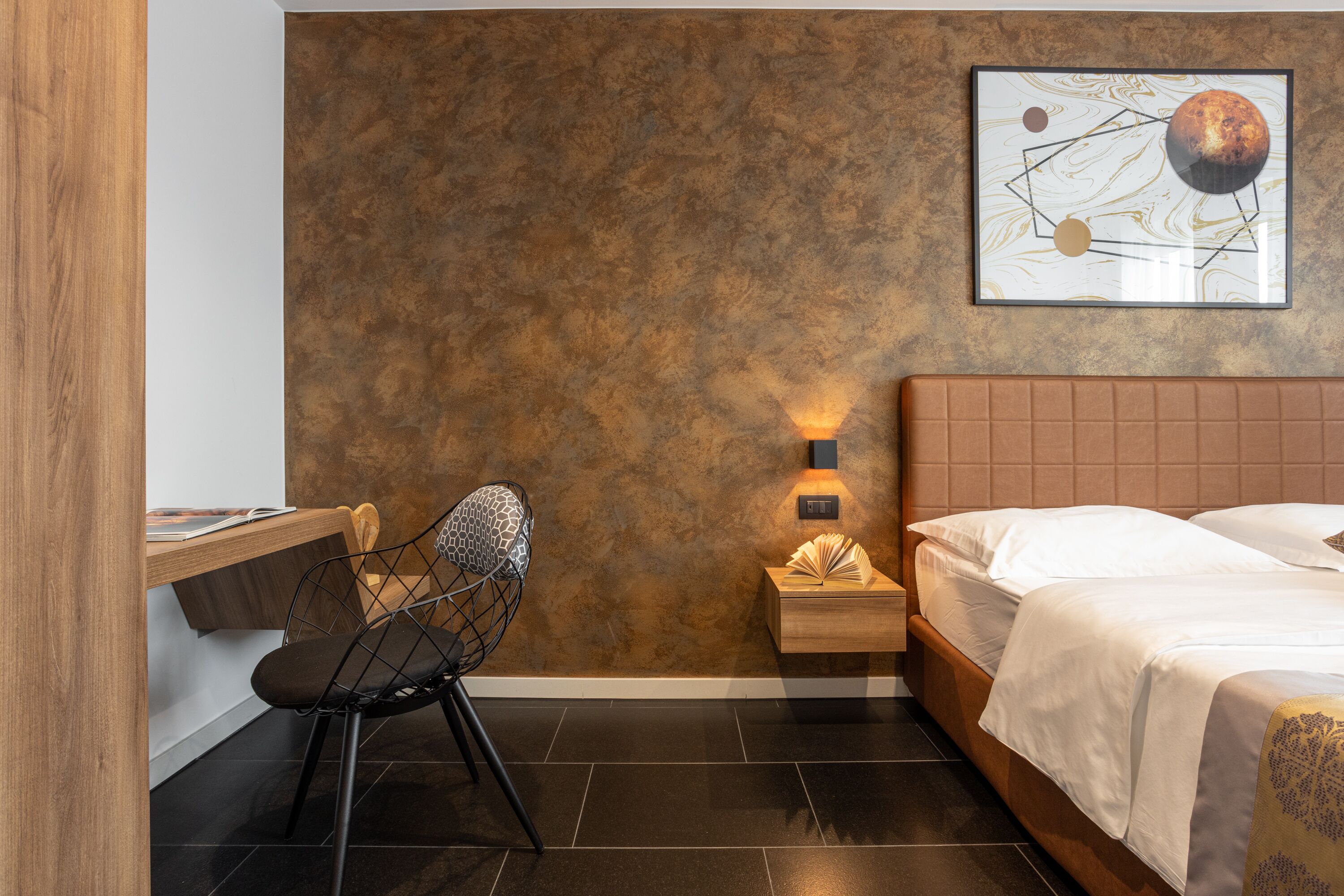 A modern bedroom with a bed, a desk, and a chair.