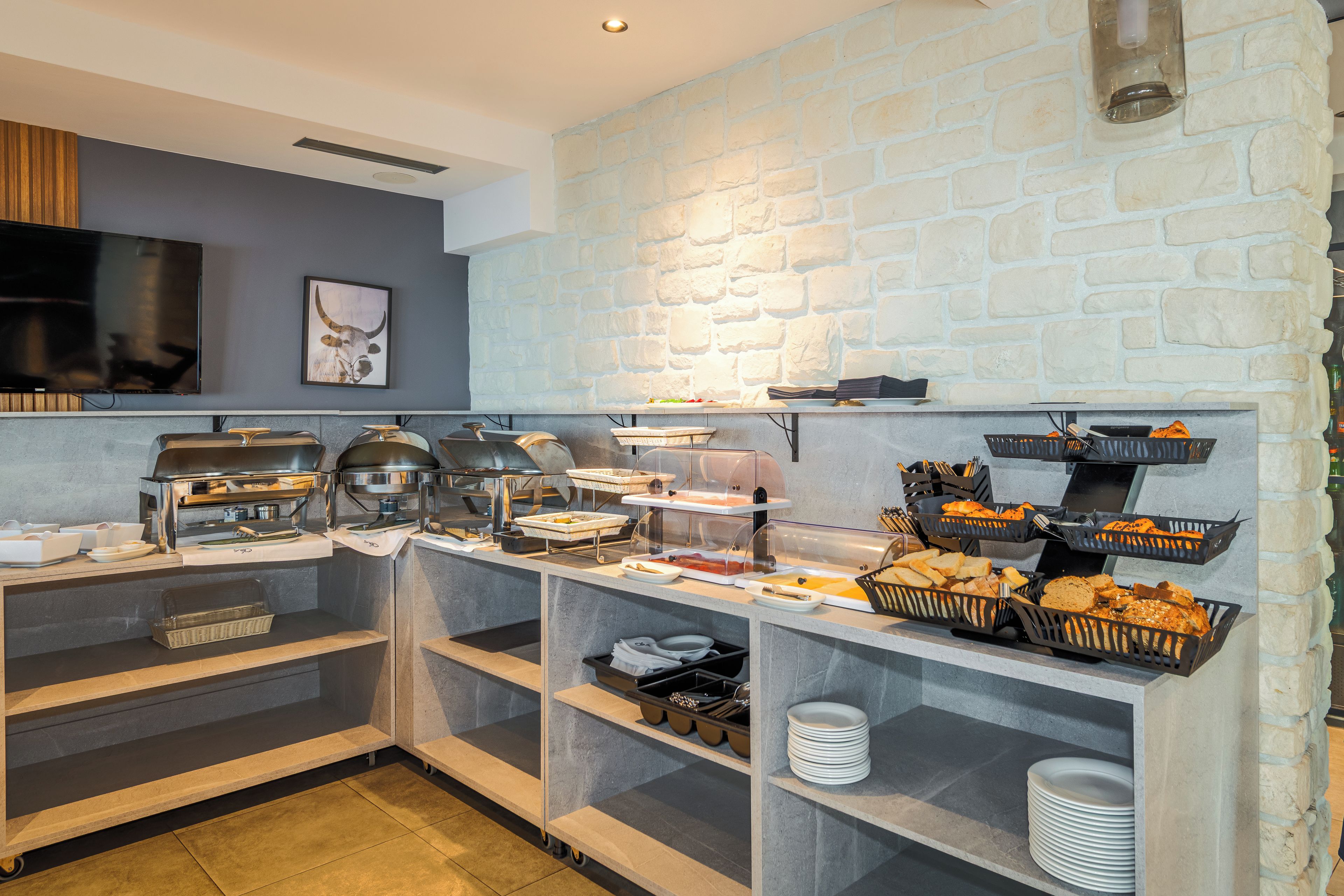A buffet setup with various food stations, including a grill and a display of bread.