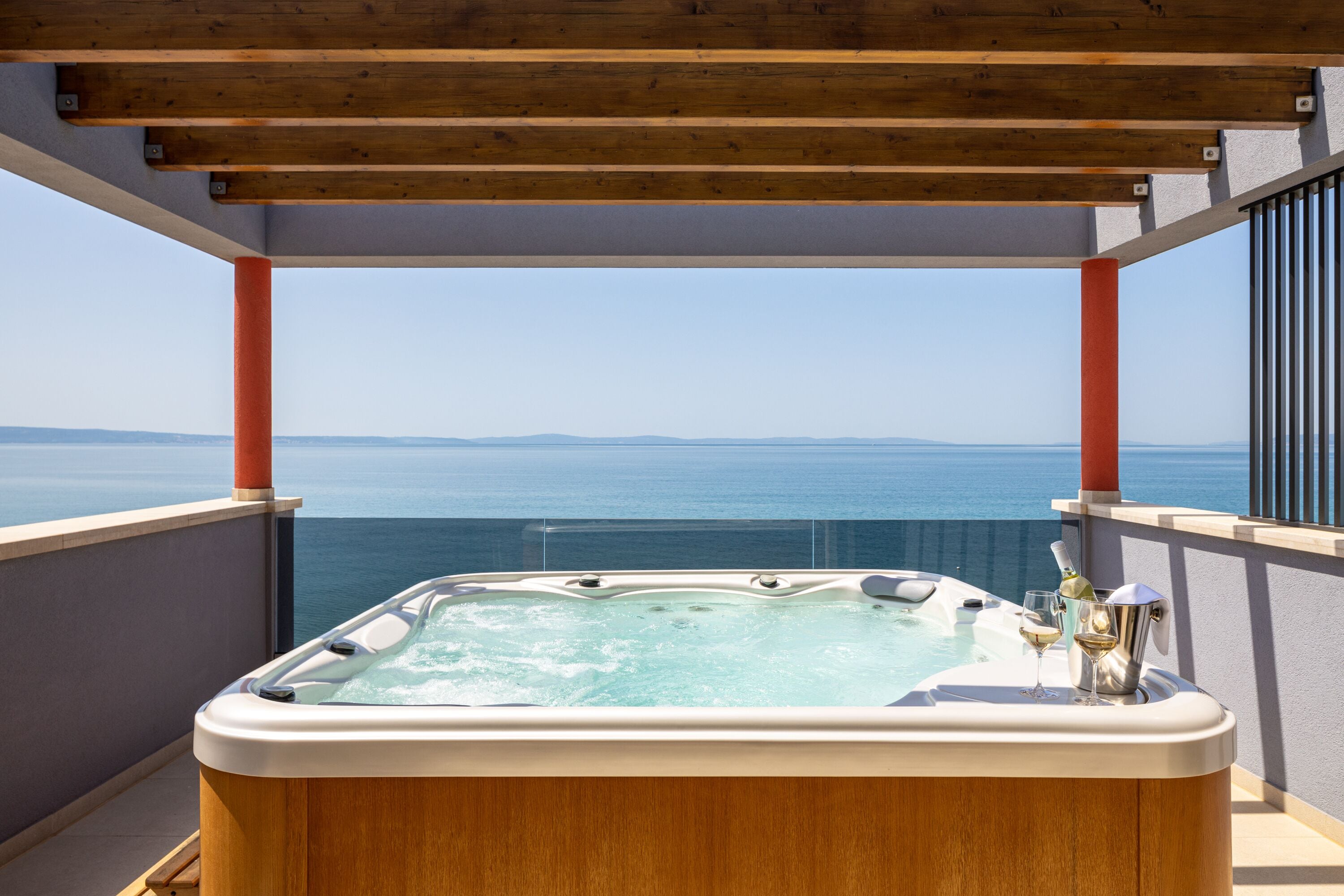 A hot tub with a clear view of the ocean and distant land.