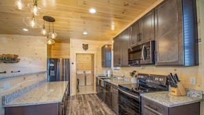 A modern kitchen with granite countertops, stainless steel appliances, and wooden cabinetry.