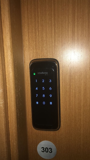 Un clavier avec la marque « Intelbras » et le numéro « 303 » en dessous.