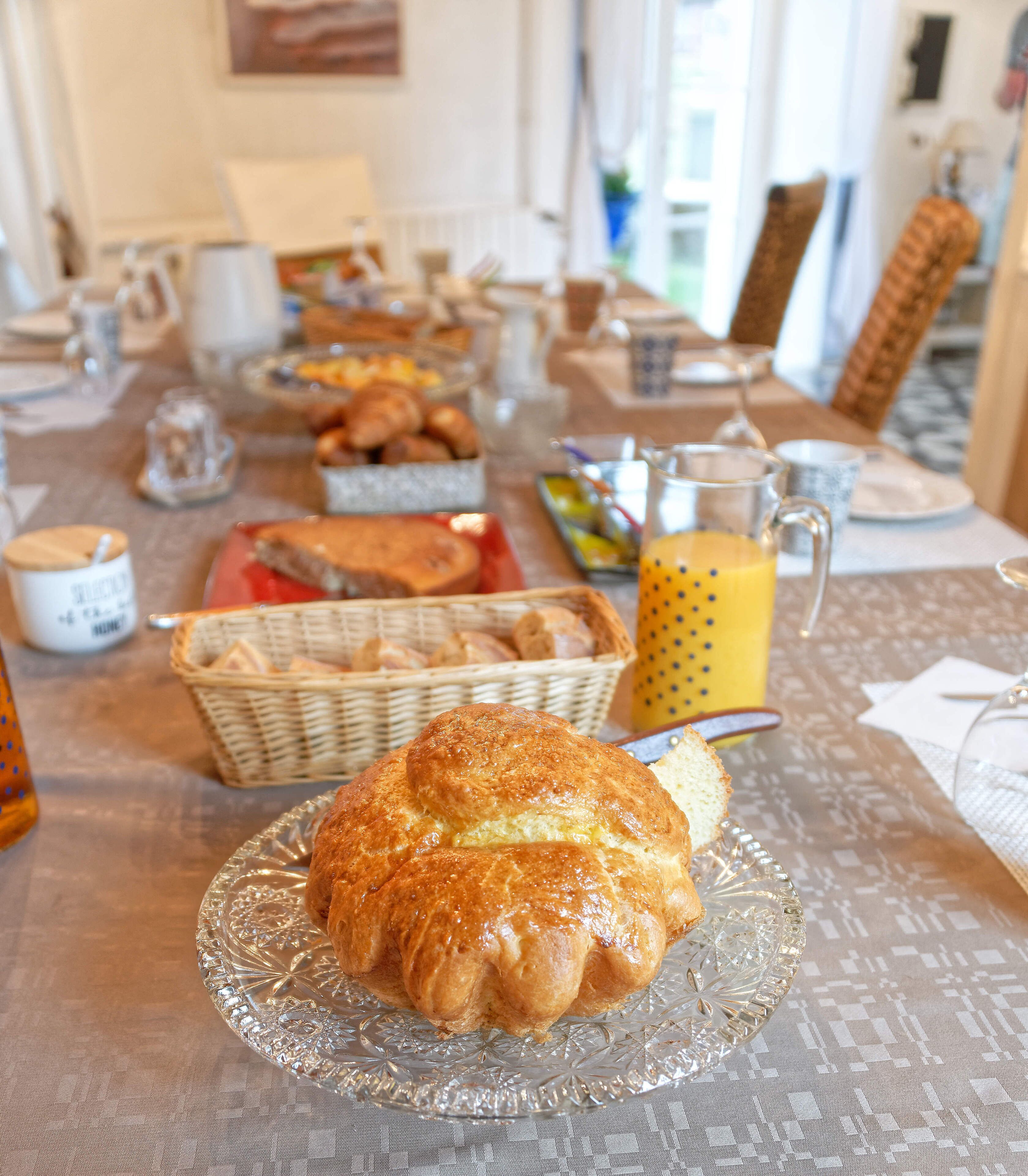 A breakfast buffet with various pastries and a glass of orange juice on a table.