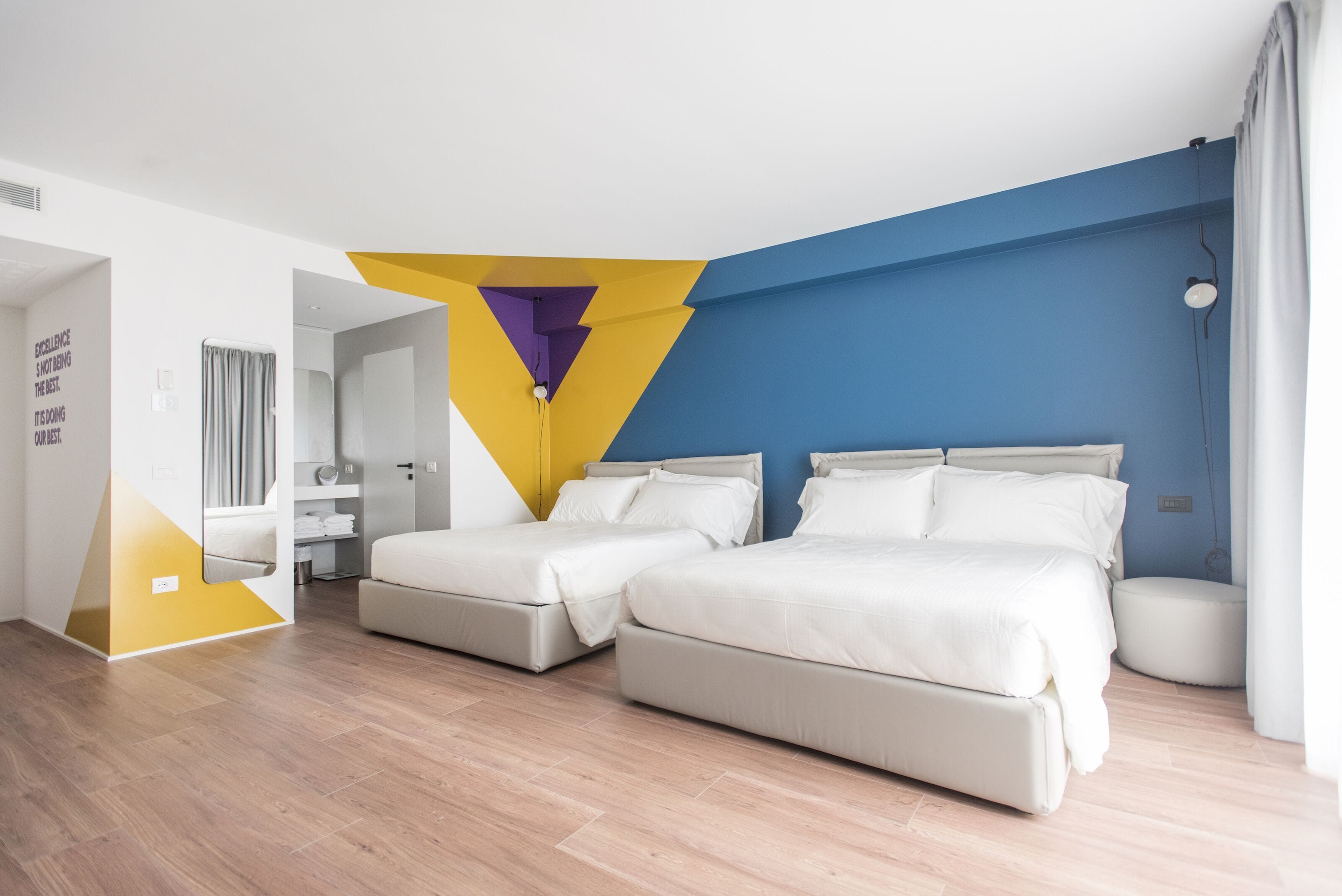 Une chambre d’hôtel moderne avec deux lits, une salle de bain et une vue sur la ville.
