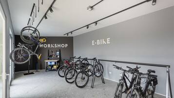 A bike workshop with multiple bicycles, a workbench, and tools.