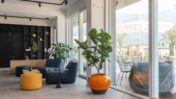 Ein modernes Interieur mit einer Couch, Hocker und Topfpflanzen.