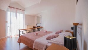 A bedroom with two beds, a bedside table, a lamp, and a window with curtains. - Village House Imotski (Imotski)