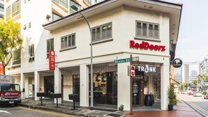 A building with a RedDoorz sign, a TRONK store, and a Guinness sign. - RedDoorz Premium @ Balestier (Singapore)