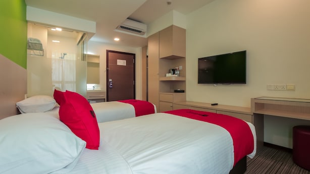 A hotel room with two beds, a TV, a desk, and a mirror. - RedDoorz Premium @ Balestier (Singapore)