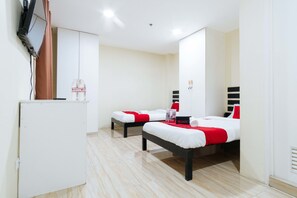 A hotel room with two beds, a small white refrigerator, and a television mounted on the wall. - RedDoorz @ University Belt Manila (Manila)