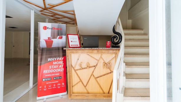 Un área de recepción con un letrero de RedDoor, una computadora Lenovo y un escritorio de madera.