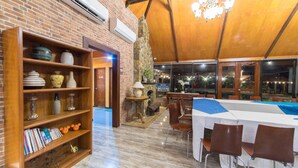 A restaurant with brick walls, wooden shelves, and a high ceiling with chandeliers. Tables and chairs are set up for dining. - RedDoorz Plus @ Starhomes Olivianville (Tarlac)