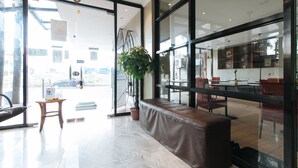 Un intérieur moderne avec un coin salon, une plante en pot et une vue sur la rue.