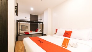 Une chambre d’hôtel avec un lit superposé, un lit simple et une grande fenêtre.