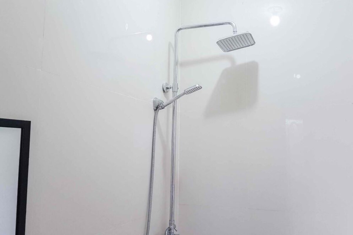 A shower with a handheld showerhead and a fixed overhead showerhead.