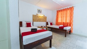 A hotel room with two beds, a wooden headboard, a nightstand, and a wall-mounted light fixture. - RedDoorz Premium @ Clarkview Angeles City (Angeles City)