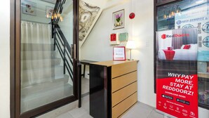 A reception desk with a framed certificate, a lamp, and a RedDoorz advertisement. - RedDoorz @ Salinas Extension Lahug (Cebu City)