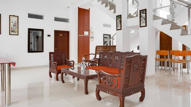 A spacious lobby with a modern staircase, wooden furniture, and a polished floor. - RedDoorz near Jawa Timur Park 3 (Batu)
