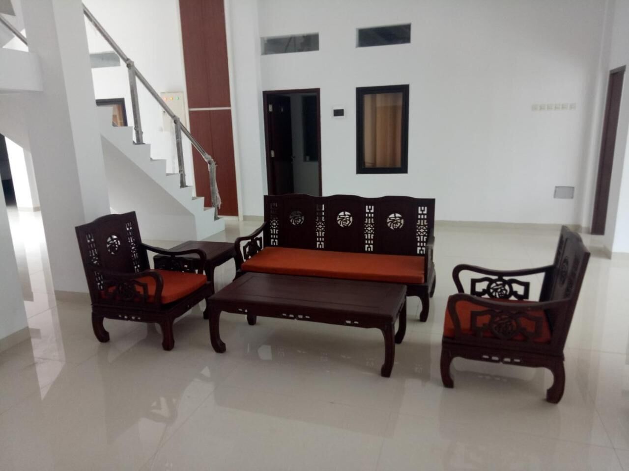 A living room with a sofa set, two armchairs, and a coffee table.