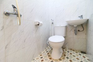 Un baño con inodoro, lavamanos y ducha.