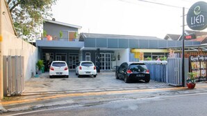 Il s’agit d’un bâtiment sur lequel on peut lire les enseignes « Lien Hair Salon » et « Queen Body Clinic ». Trois voitures sont garées devant.