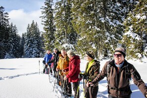 A group of people in a snowy forest setting.