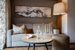Un salon moderne avec un canapé gris, une table basse ronde et un lampadaire.