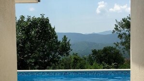 Una piscina con vistas a montañas y árboles.