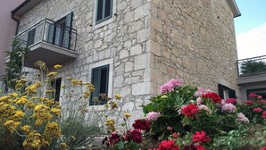 Un edificio de piedra con un balcón y contraventanas.