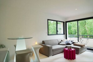 Departamento de diseñador, vista al jardín (Chambre ZYX) | Área de sala de estar | Smart TV de 42 pulgadas con canales digitales y televisión 