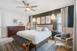 A bedroom with a bed, a bench, a chair, a dresser, and a ceiling fan. - Amazing+Modern Coastal Resort+ Clearwater-Dunedin+ Pool+Backyard Oasis+Beaches (Dunedin)
