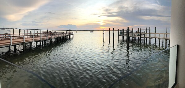 A pier extending into calm waters with a sunset in the background. - Amazing+Modern Coastal Resort+ Clearwater-Dunedin+ Pool+Backyard Oasis+Beaches (Dunedin)