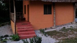 A single-story building with a thatched roof and a red staircase leading to the entrance. - Kilindoni Sea View Bungalows (Mafia Island)