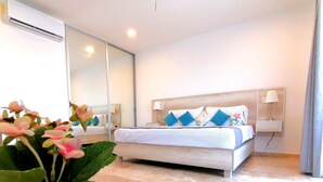 Een moderne slaapkamer met een groot bed, bedlampen, een spiegel en een potplant.