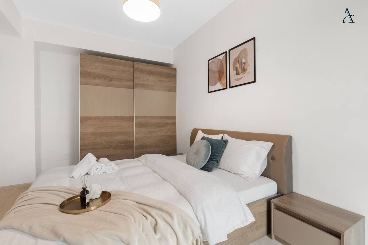 Un dormitorio moderno con cama, mesita de noche y un armario de madera.