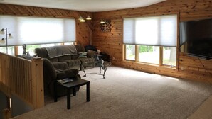 Ein gemütliches Wohnzimmer mit einer Couch, einem Couchtisch und einem Fernseher.