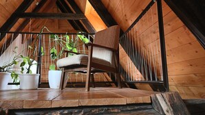 A wooden chair in a loft-style room with a sloped ceiling, wooden beams, and potted plants. - Apartment Soukenická 44 (Cesky Krumlov)