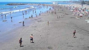 Playa en los alrededores, playa de arena negra y bar en la playa