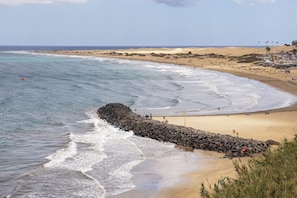 Playa en los alrededores, playa de arena negra y bar en la playa