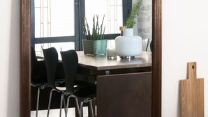 A dining area with a wooden table, black chairs, a potted plant, and a white vase. - La Pietra B&B (Grottazzolina)