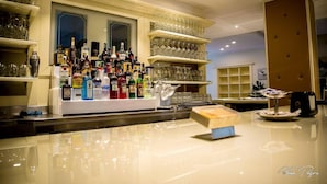 Eine Bar mit Regalen voller Spirituosenflaschen und Gläsern.