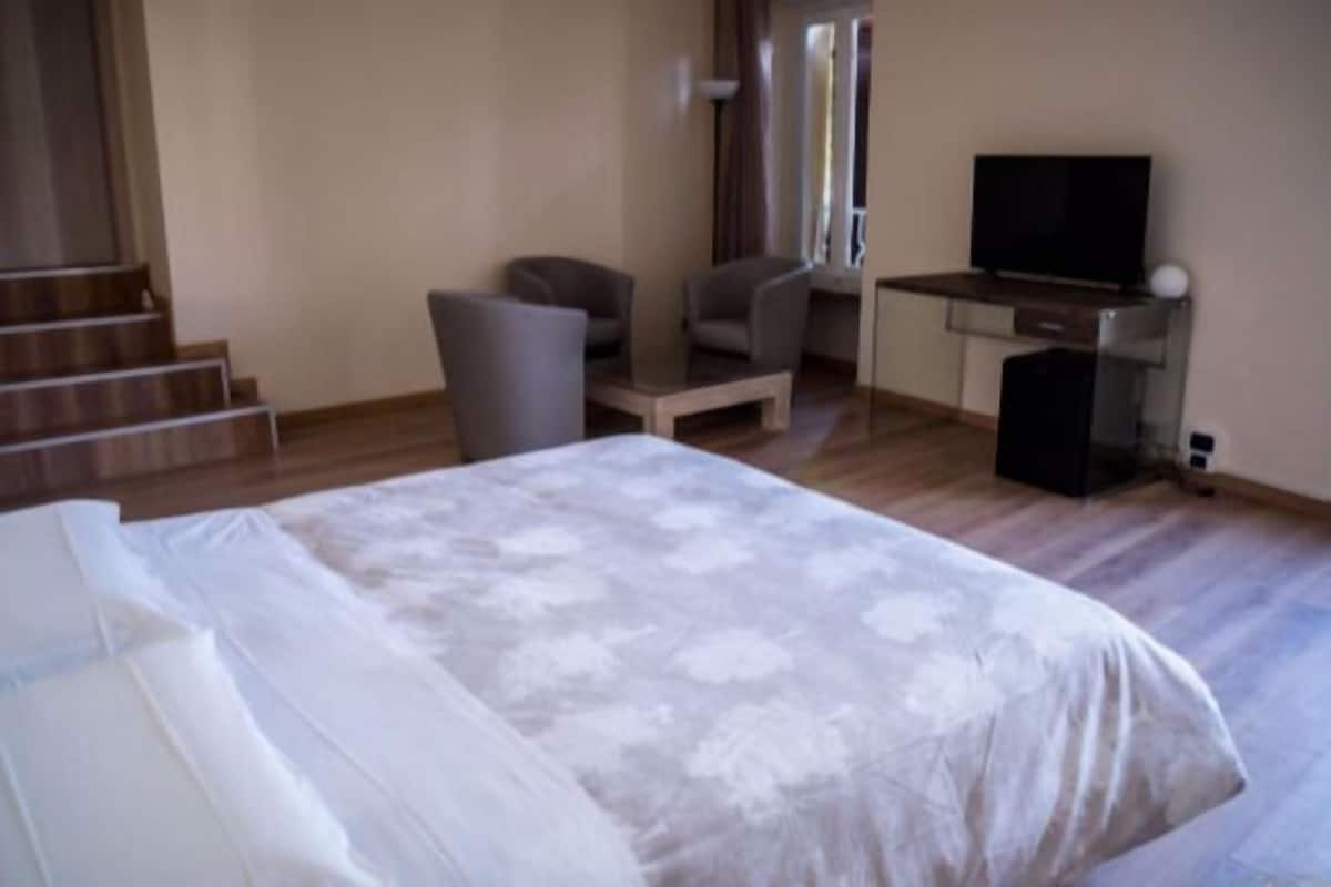 Een hotelkamer met een bed, een bureau, een stoel en een televisie.